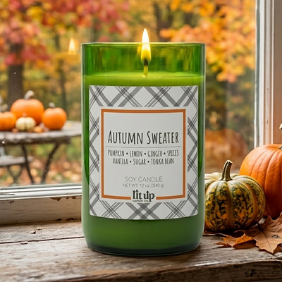 Autumn Sweater 12 oz. soy candle lit with pumpkins in the background