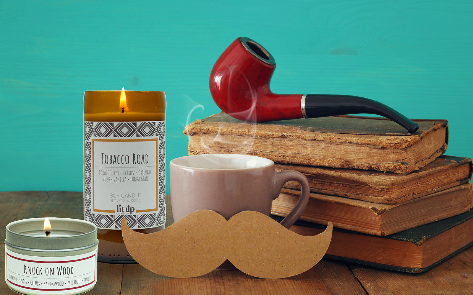 Tobacco Road and Knock on Wood candles with a coffee mug, pipe, and old books.